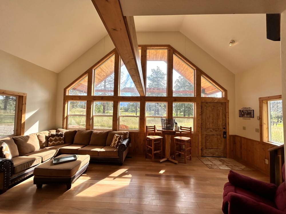 A-frame living room looking out through the two-story window wall