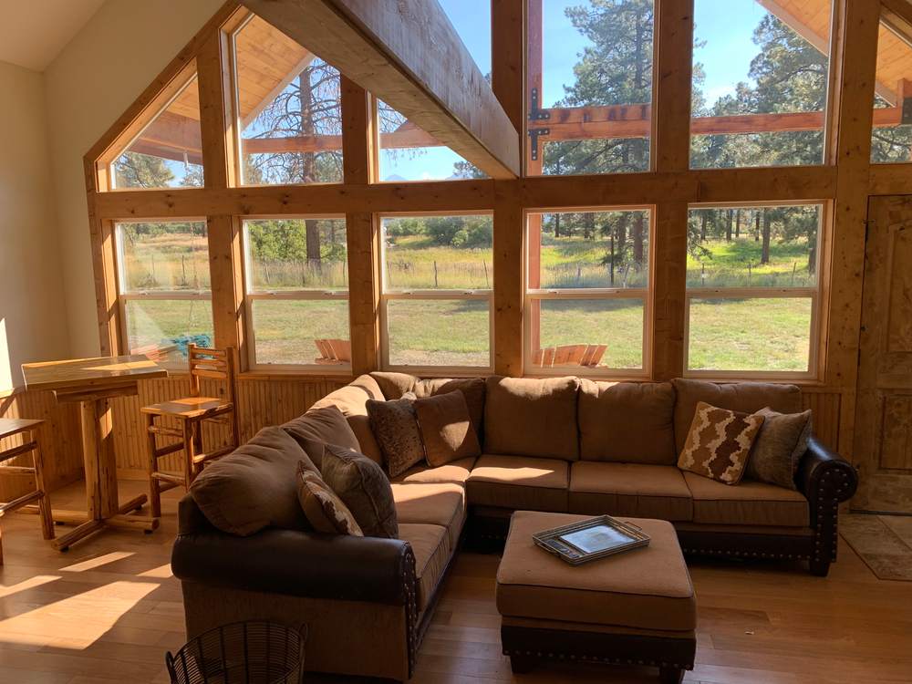 Big sectional sofa in front of the A-frame's window wall