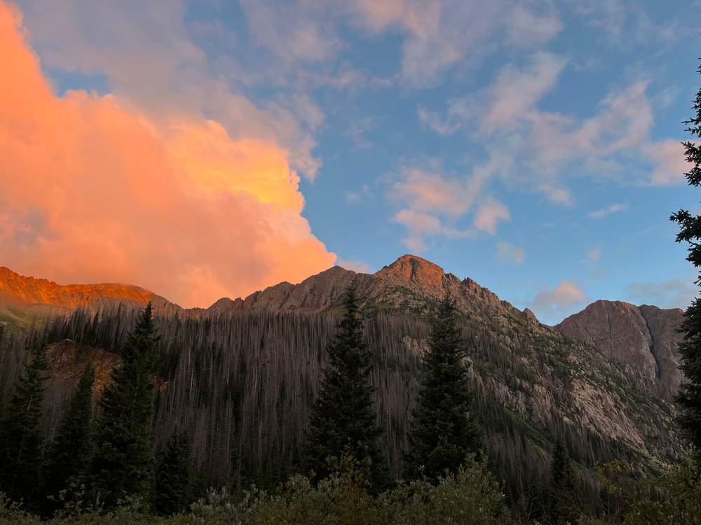 Alpenglow lighting up clouds over the San Juan mountains at dusk