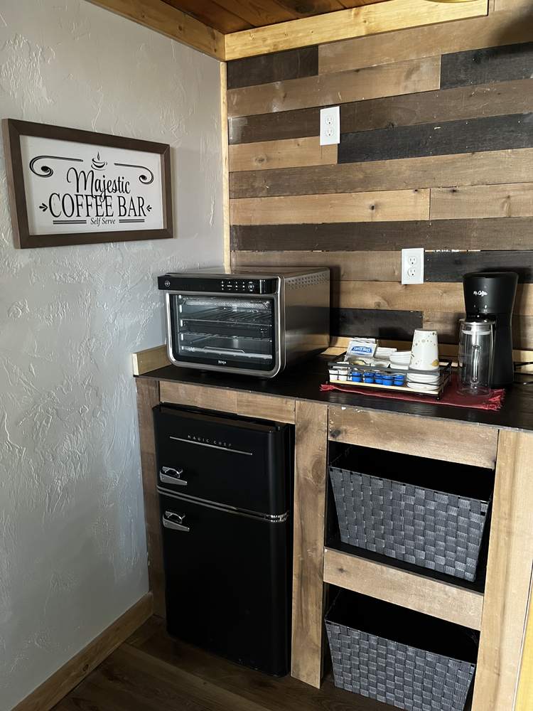 Cabin coffee bar with toaster oven and mini fridge against a reclaimed-wood wall