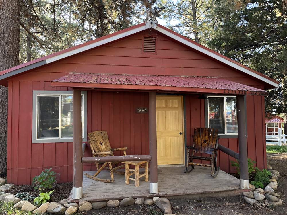 The red two-bedroom cabin with its covered front porch and wooden rockers