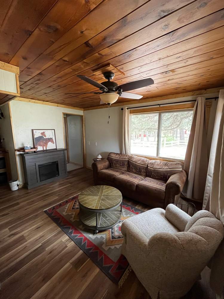 Cabin living room with leather sofa, wood ceiling and fireplace