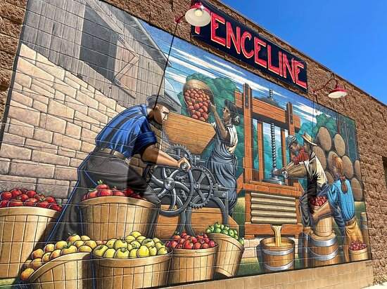 The painted Fenceline Cidery mural on a brick wall in Mancos