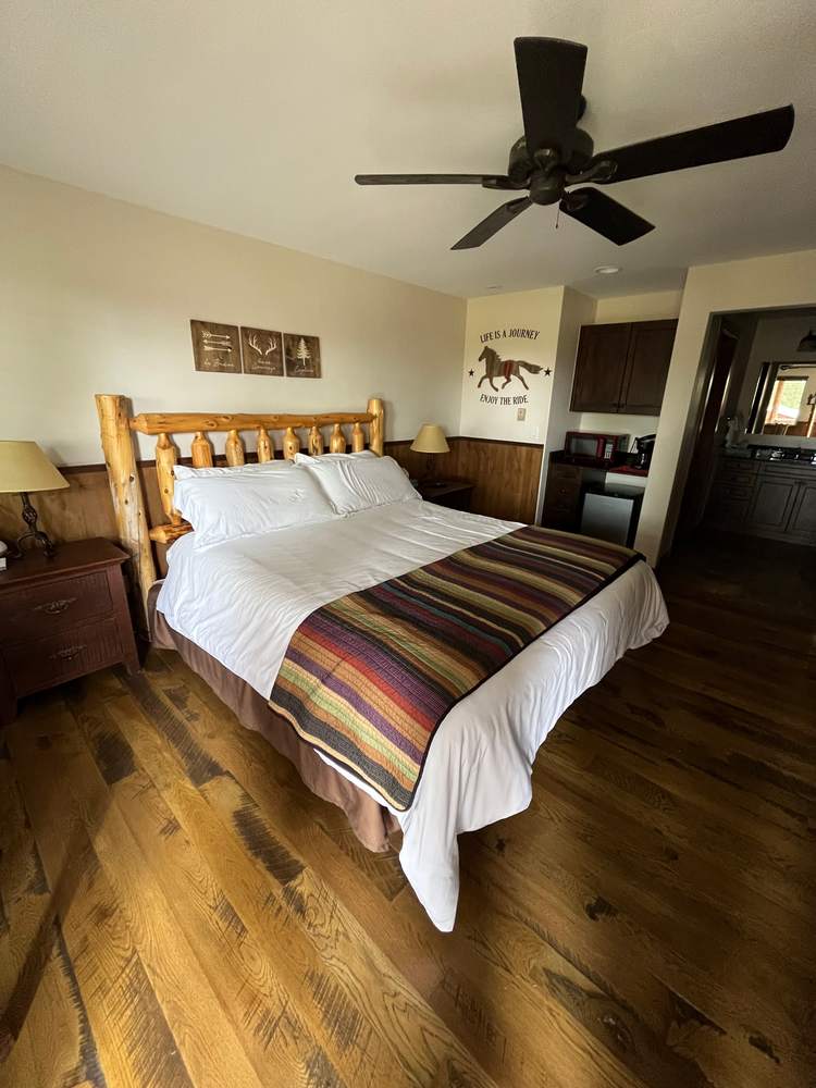 King suite with a log-frame king bed and striped wool blanket