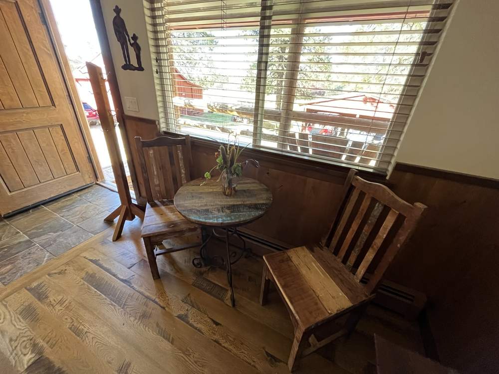 King Suite entry with a small table and rustic chairs by the window