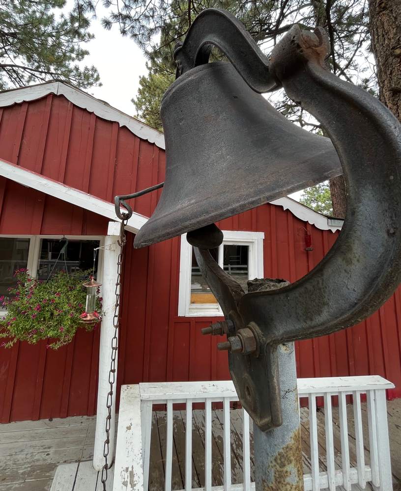 The old iron ranch bell in front of a red building
