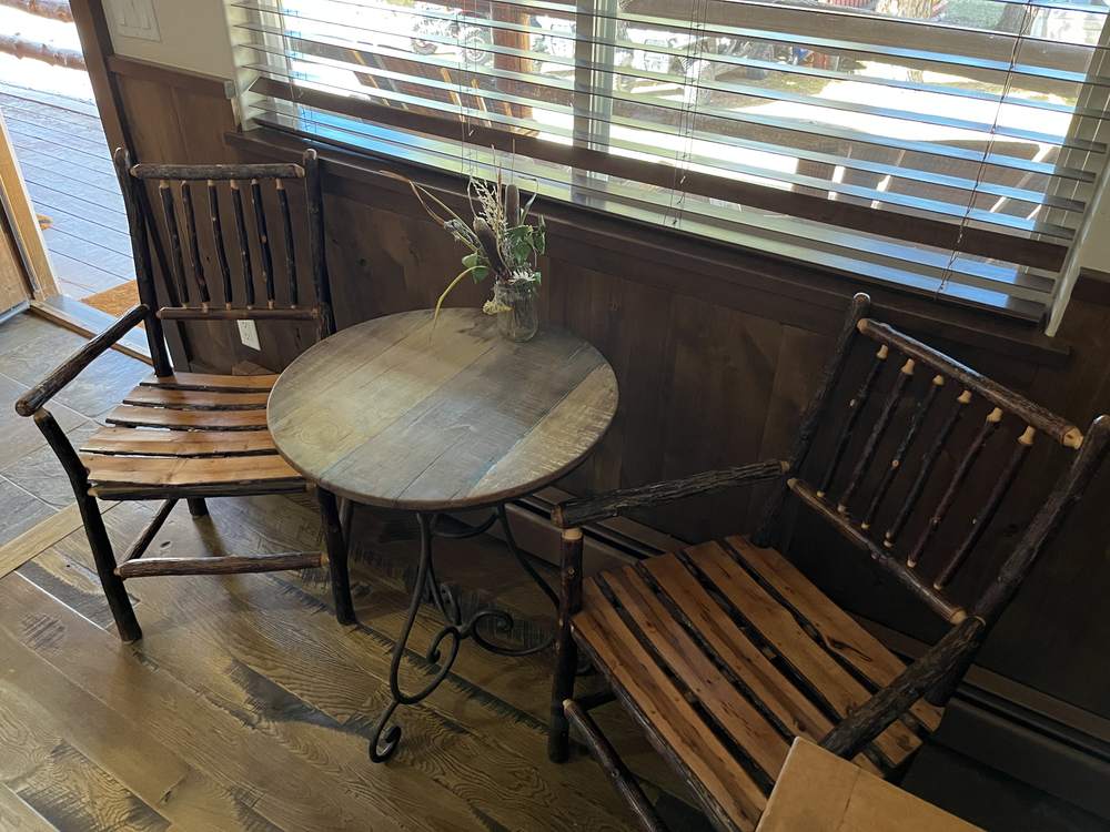 Round porch table with two twig-style chairs outside the suite