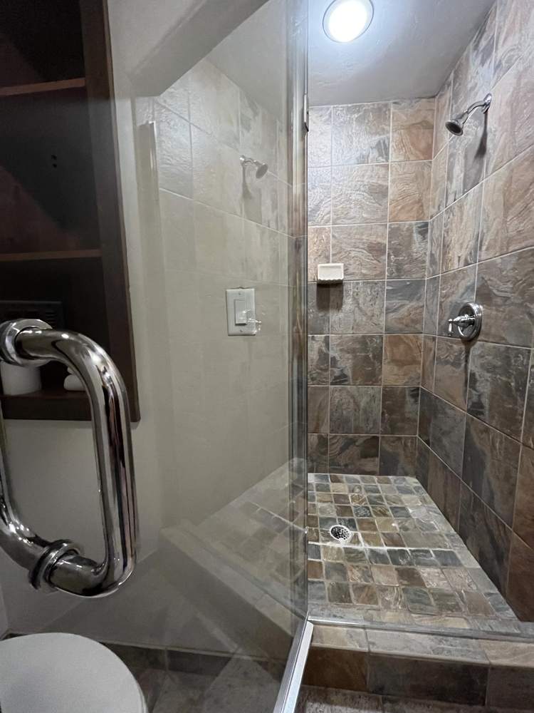 Glass-front stand-up shower with slate tile