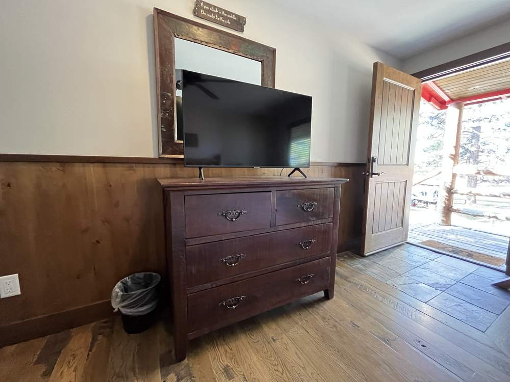 Suite dresser and smart TV beside the open door to the porch